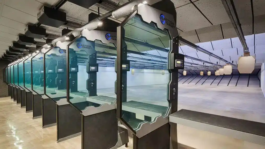 Row of Action Target shooting stalls with ballistic glass dividers, digital controls, and bright indoor range lanes.