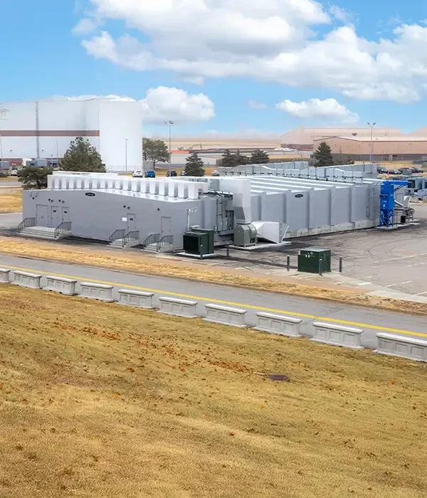 A large gray facility with surrounding warehouses and road in the foreground.