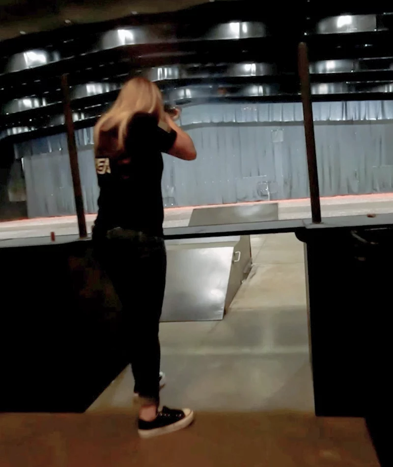 Lady shooting a shotgun at an indoor commercial shooting range