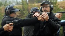 Firearms instructor guiding trainees during live fire training exercise.