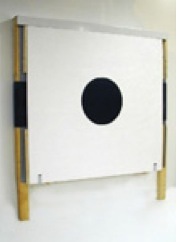 Paper shooting target backer with a centered black bullseye mounted on a wooden frame.