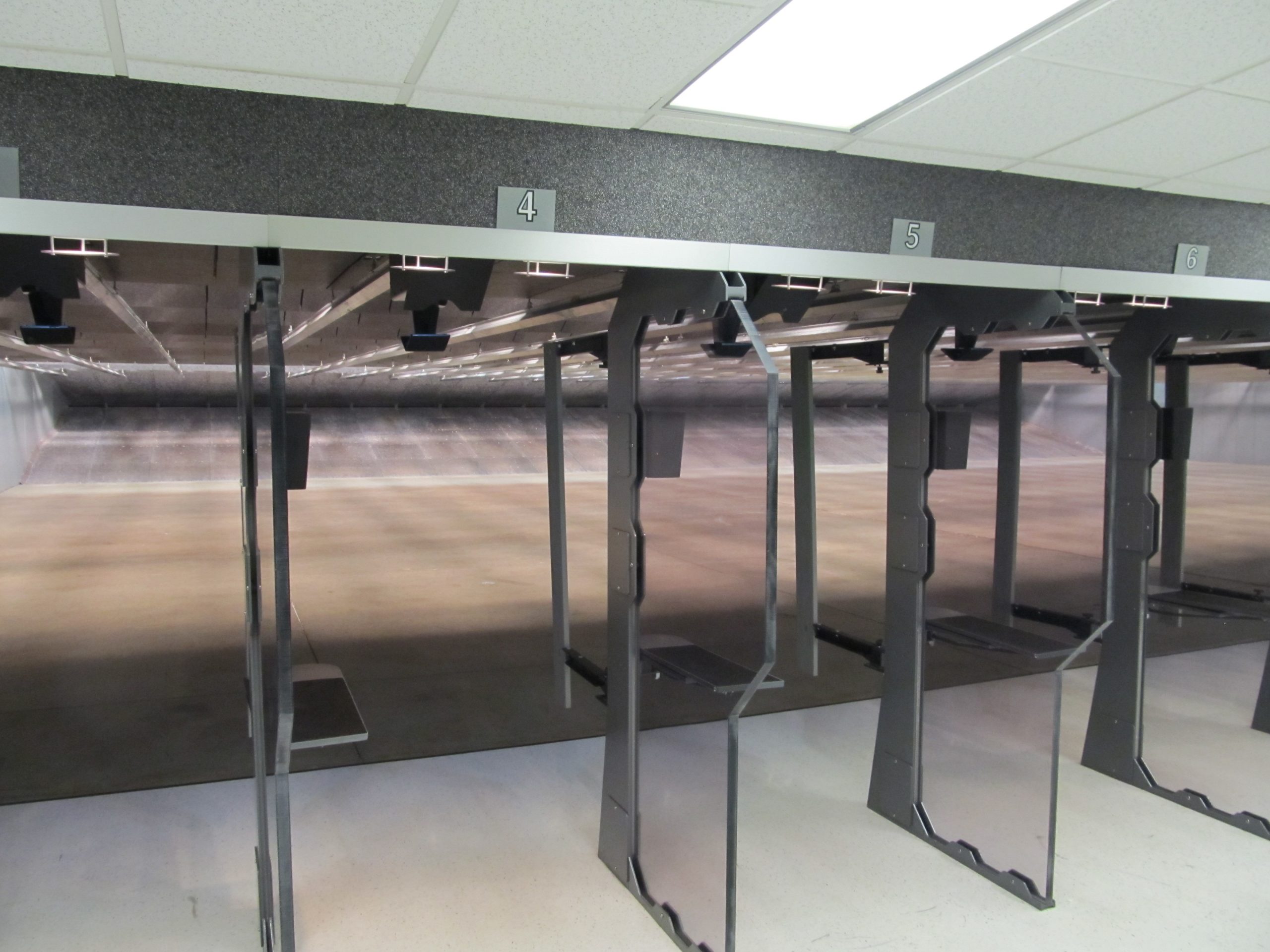 Shooting lanes at an indoor firing range, numbered 4 to 6, with target rails above.