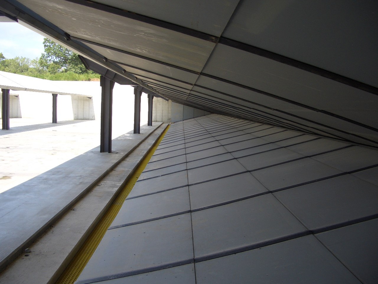 Outdoor shooting range bullet trap with angled steel panels and overhead baffles designed to safely capture fired rounds.