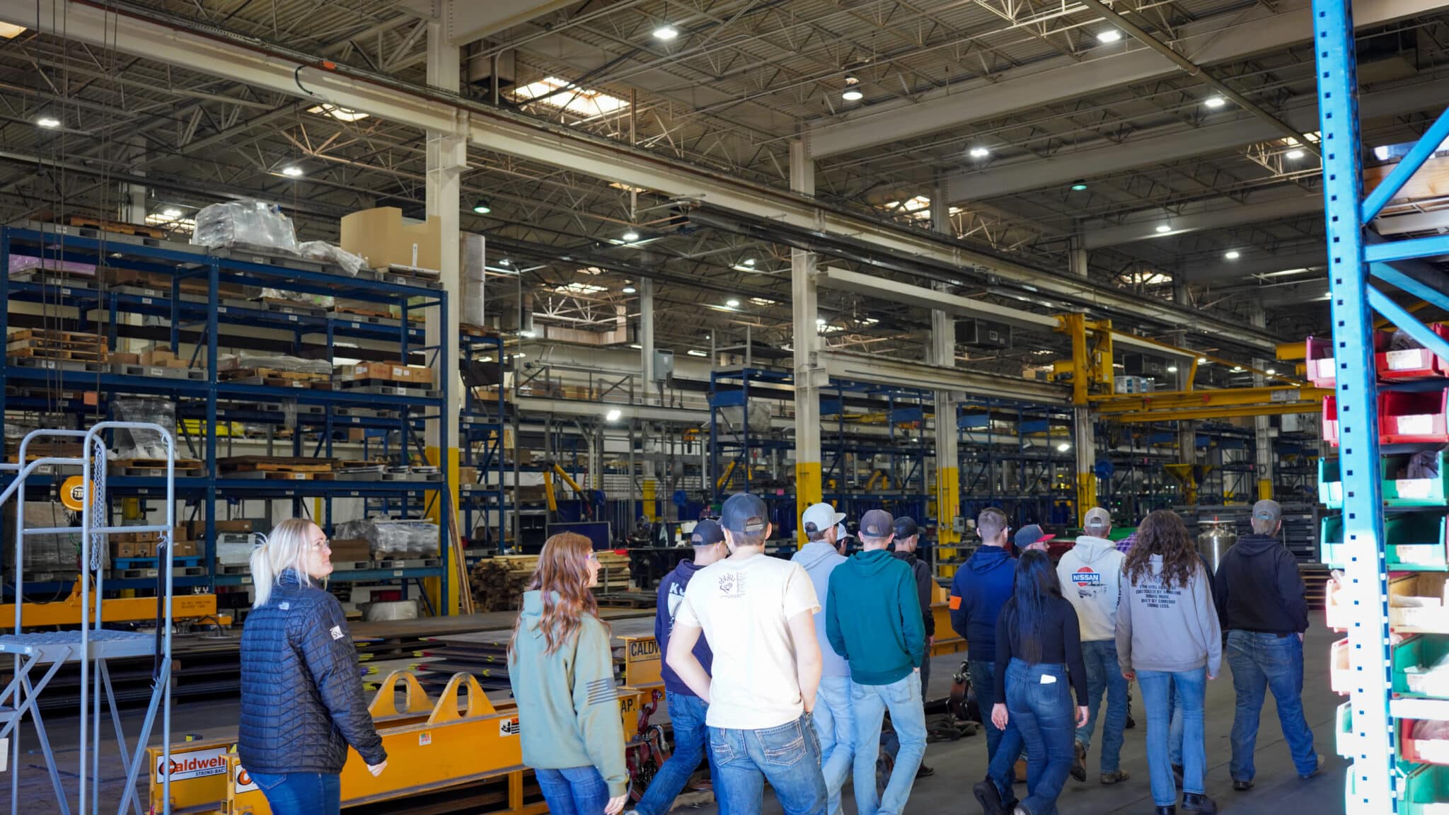 Group of people touring a large manufacturing facility.