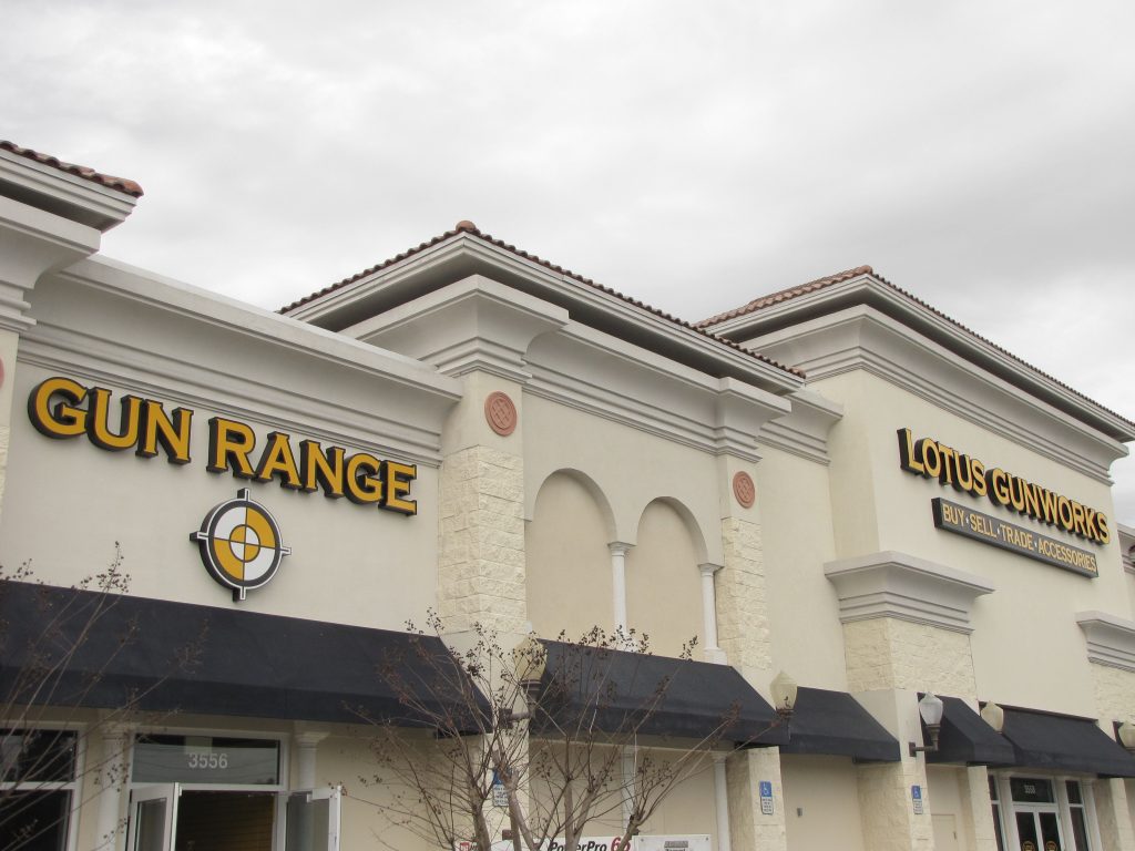 Exterior of a gun range and Lotus Gunworks storefront.