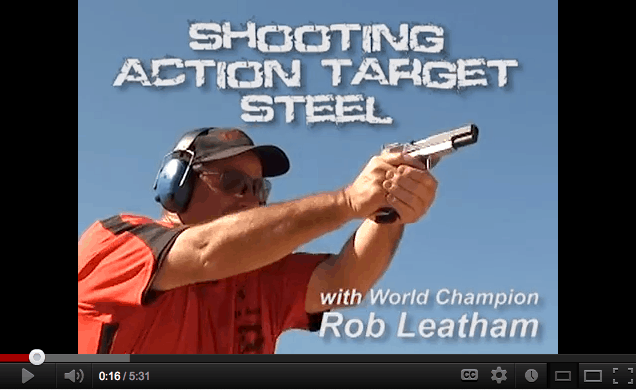 Promotional video still showing competitive shooter Rob Leatham aiming a handgun during a steel target shooting demonstration.