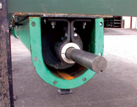 Metal rod protruding from a green housing structure, positioned in an industrial outdoor area.