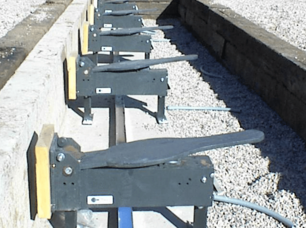 Row of outdoor shooting range reactive steel targets mounted on pivoting mechanisms