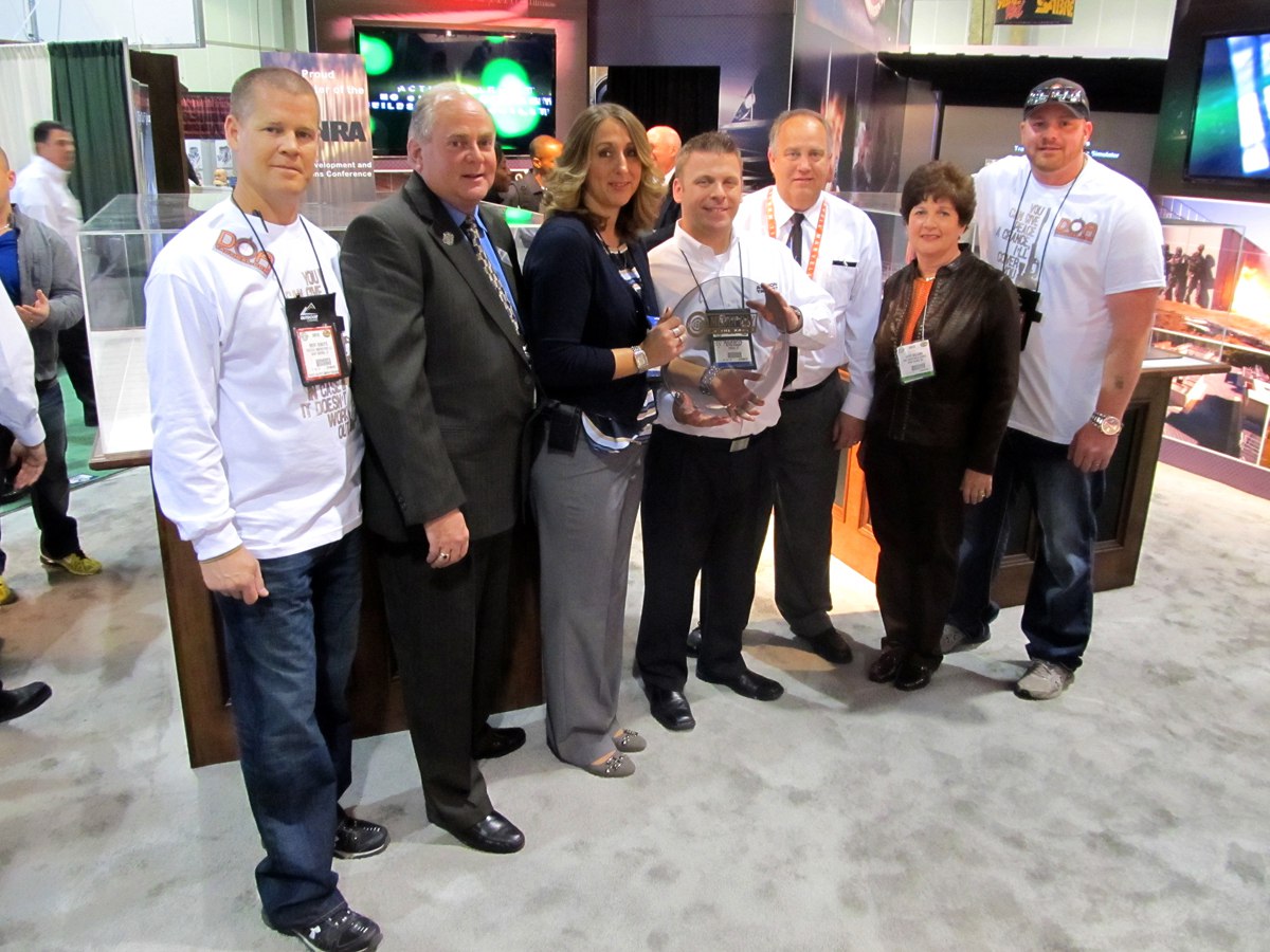 Group of people at an event holding an award together.