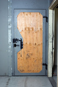 Reinforced training door with mounted hardware inside a range facility.