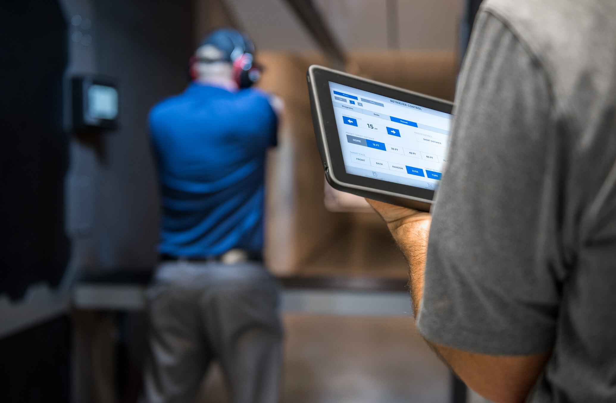 Man holding Action Target's SmartRange Axis tablet