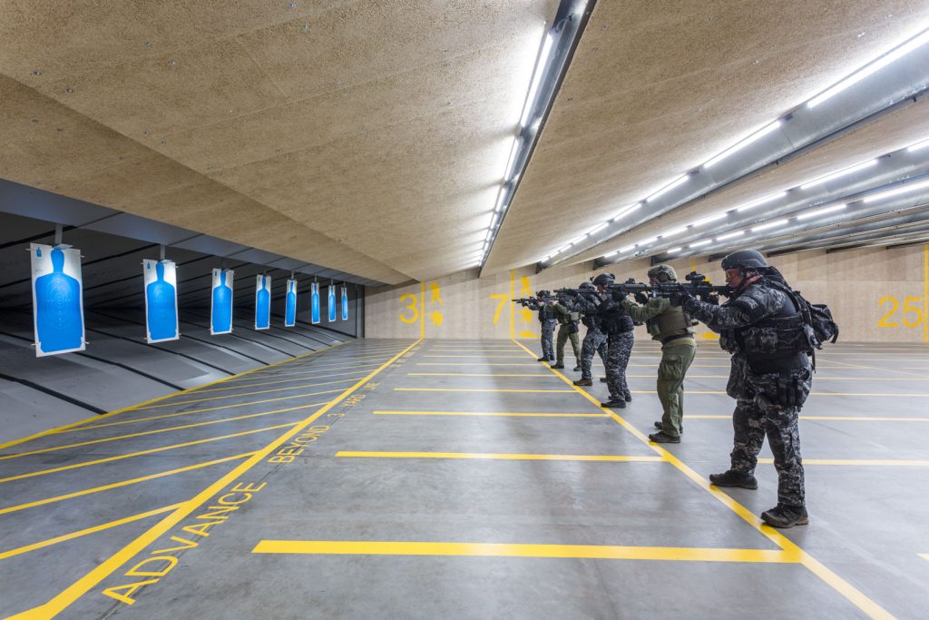 SWAT team lined up shooting in an indoor shooting range